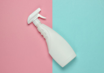 White bottle of spray for cleaning on a blue pink pastel background. Top view. Minimalism