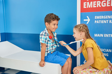 31.07.2017 - Kyiv, Ukraine. Two children playing doctor in playroom. Little girl doctor examining boy patient with toy stethoscope. Childrens role play center.