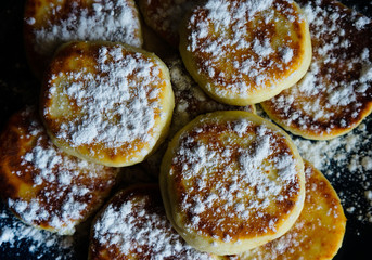 cottage cheese pancakes with icing sugar on a blue plate, home recipe