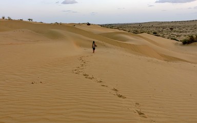 Fototapeta na wymiar Man leaves foorprints in the dunes of a Indian desert