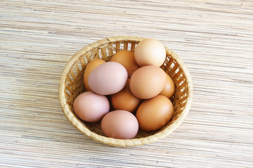 Real farm chicken eggs lie in a wicker basket on the table. The view from the top