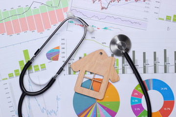 Medical statistics and analytics. Stethoscope and house figure, graphs and charts.
