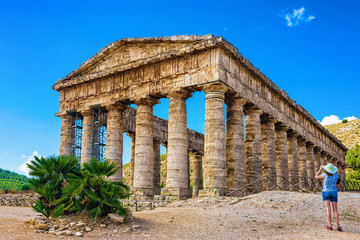 Woman takng photos at Doric temple in Segesta on Sicily