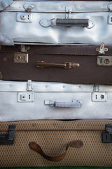 Vintage weathered leather and metal suitcases on top of each other. Retro. Background
