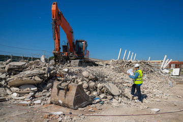 Engineer is checking for the area of dismantling of an old factory before making the new design and...