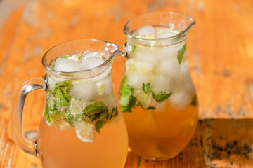 two mugs with mojito on wooden table