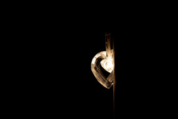 Heart-shaped light bulb in a dark room