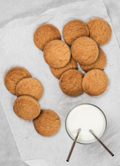Shortbread oatmeal cookies with milk on a dark gray background