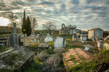 Fototapeta na wymiar Abandoned church ruin and cemetery overgrown landscape