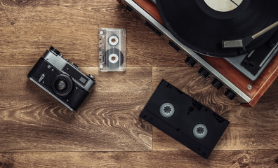 Old vinyl record player, video cassettes, audio cassette, old-fashioned film camera on the floor....