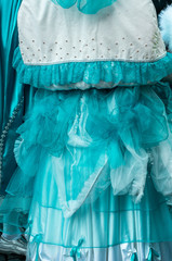 Close up of details of mint green carnival dress with lace and satin. Ornate ruffles and white fabric shot in natural light from behind.
