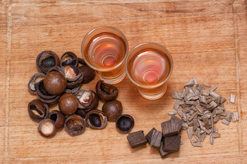 Two shot of home-brewed whiskey stand on a wooden board