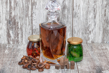 A curved crystal decanter with homemade moonshine stands on a wooden stand