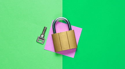 Lock with key on a colored paper background. Top view