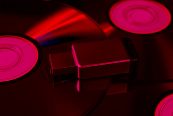 USB flash drive on CDs. Pink neon light