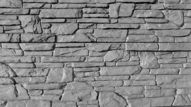 concrete fence of slabs imitating natural stone grey color