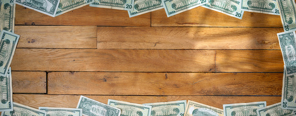 Banner sized background of used dollar banknotes lying on wooden floor. Reverse (back) side up.