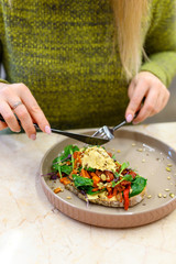 toast with homemade hummus and baked vegetables and woman ready eats. vertical photo