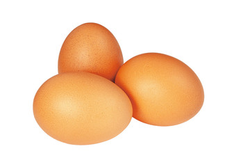 Three brown chicken eggs close up lie in a group on a white background.