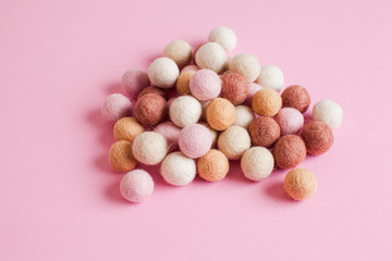 Fototapeta na wymiar Pale of soft wool balls on pink background