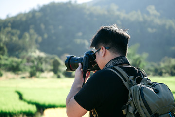 Backpack adult male photographer travelling in to the valley.