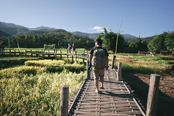 Backpack adult male photographer travelling in to the valley