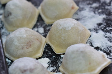 Fresh cooked meat dumplings on a baking sheet