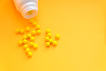 Yellow pills, vitamin C on a yellow background copy space. Concept of medicine, health and body care