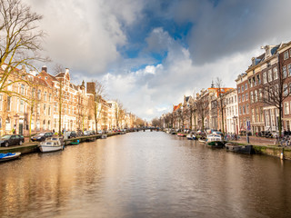 Naklejka premium Amsterdam City Canal view with cloudy sky background