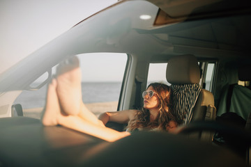 Woman sitting in the driver's seat in a van with mini skirt