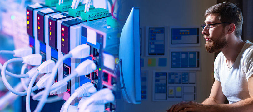 A person is working at a computer against the background of connected wires. System administrator at work. The man is engaged in computer networks. Remote work of the programmer.