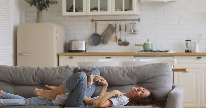 Happy attractive young mother lifting overjoyed little daughter.