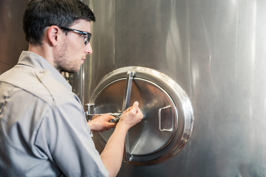 Technician opening up hatch on a steel tank. Red Lodge, Montana, USA