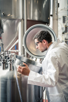 Technician visually monitors processes in a steel tank. Red Lodge, Montana, USA