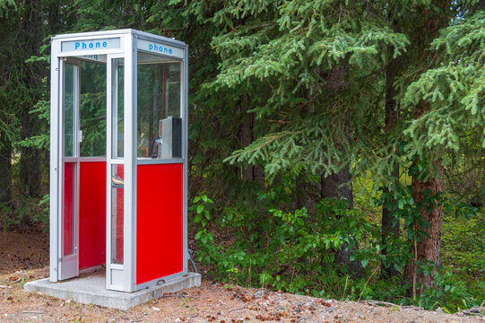 A red phone booth in the forest in Slana, Alaska