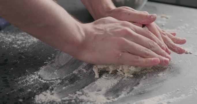 Slow motion man put dough on concrete countertop