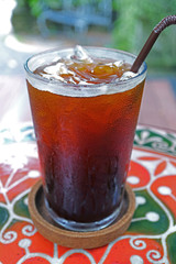 Vertical Image of a Glass of Iced Coffee on Colorful Tiled Table