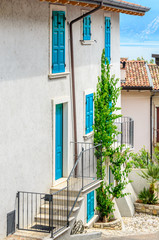 Fototapeta na wymiar Picturesque small town street view in Limone, Lake Garda Italy. Entrance of an apartment or house.
