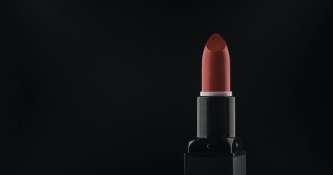 Rotation of lipstick on a black background.