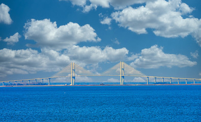 Fototapeta premium A white suspension bridge over a blue shipping channel