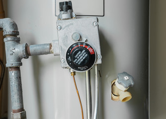 Thermostat temperature dial on natural gas hot water heater. Residential boiler tank controls for...