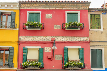 Fototapeta na wymiar Beautiful window decorated with flowers in Italy