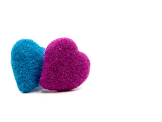 A pile of pink and blue crochet heart on white background. Felting wool