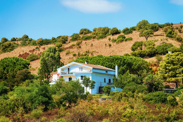 Fototapeta na wymiar House on hills and highland in Posada Sardinia