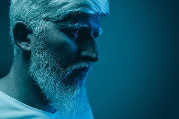 Serious tense albino man in neon studio
