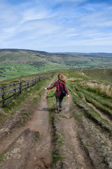 Obraz premium A woman hiking in a mountain in a green and natural landscape with sheep