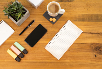 Table Top desk view with pencil a plant, coffee, workspace, mobile display and laptop