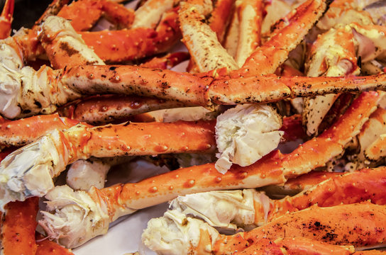 Delicious cooked king crab legs piled up on butchers paper - ready to eat - selective focus