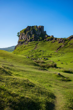 The otherworldly feel of the Fairy Glen, located at the end of a windy road near the Town of Uig, are small round-topped grassy hills with lochans, photographed on a cloudless day. 