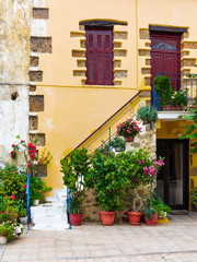 Fototapeta na wymiar A beautiful old house entrance with flowers in Crete, Greece